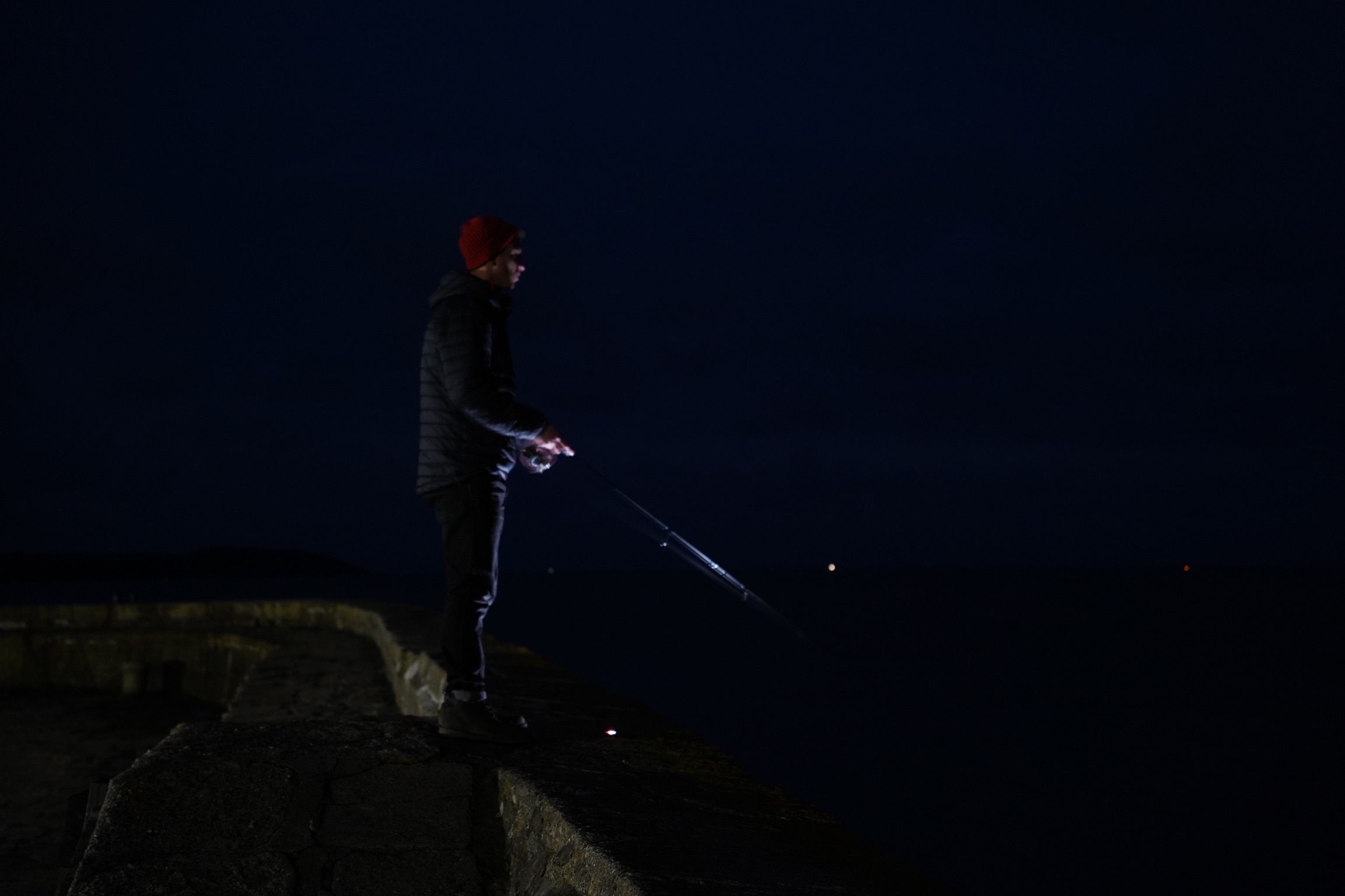 fishing at night from a harbour wall